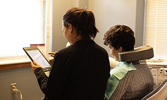 Dental team member showing a tablet to a patient