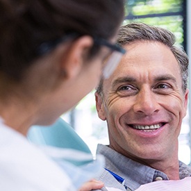 Implant dentist in La Plata speaking to a smiling patient