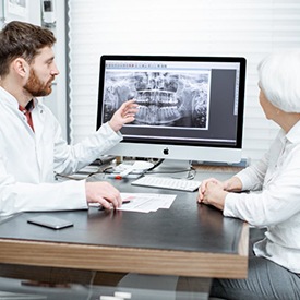 Dentist explaining cost of dental implants in La Plata to patient