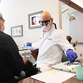 Older couple with dental implants in La Plata smiling outside