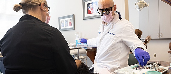 La Plata dentist grabbing a dental tool while treating a patient