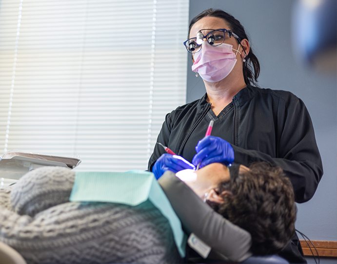 Dental team member taking intraoral photos of a patient