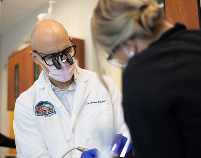 Doctor Betaharon wearing dental binoculars while treating a dental patient