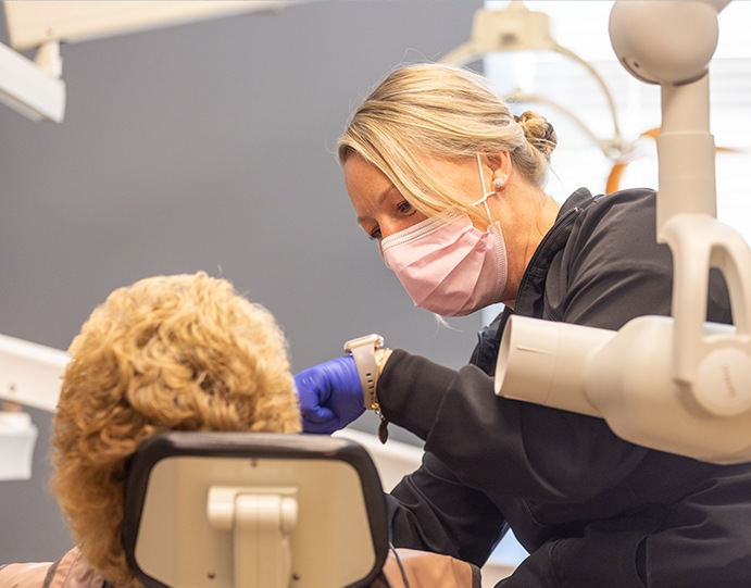 Dental team member examining a patient's mouth