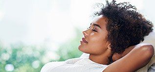 Relaxed woman with hands behind head