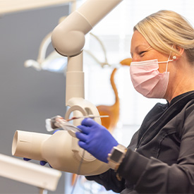 Finger pointing to highlighted teeth on digital x-rays