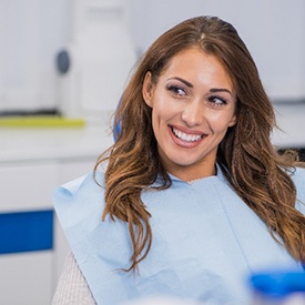 Woman with brown hair smiling while relaxing in treatment chair