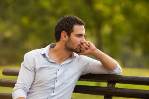 Man sitting on bench thinking.