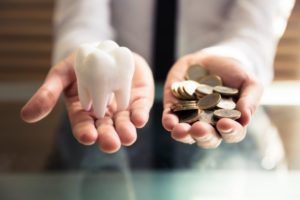 person holding a tooth and money