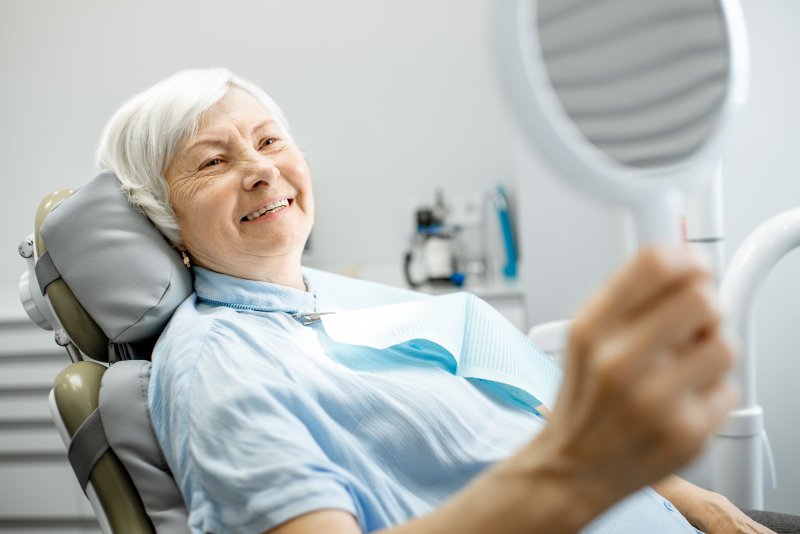 Mature female patient smiling into a mirror