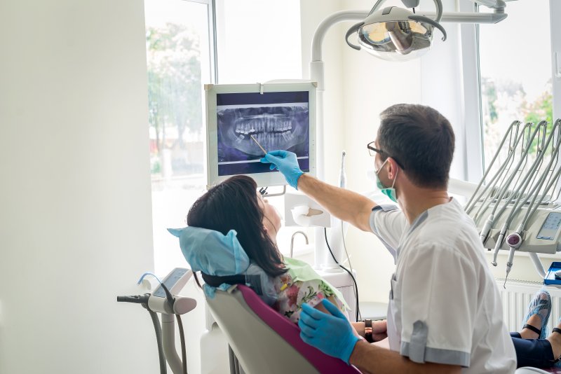 Dentist showing patient X-ray of teeth
