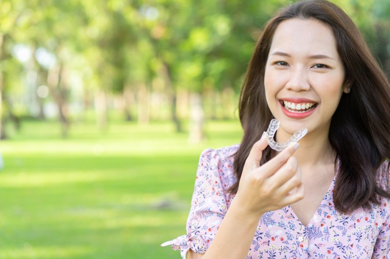 Woman holding Invisalign aligners