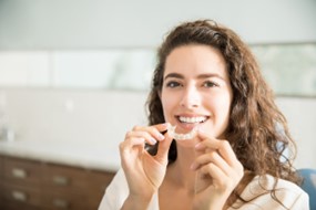 Woman removing her Invisalign aligner.