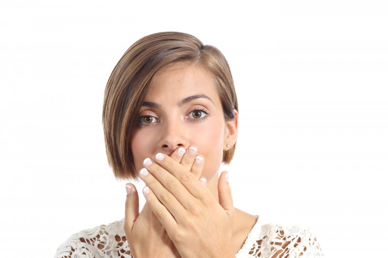 A woman hiding her lost dental crown