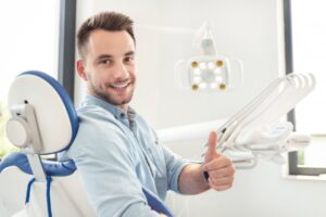 Man smiling and holding a thumbs up after his dental visit
