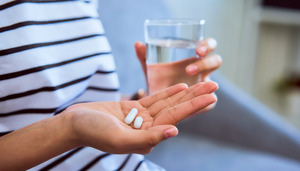 Holding glass of water and pills for oral conscious sedation